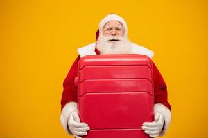 Santa Claus with his suitcase. New Year's travel concept. Santa Claus at the airport. photo