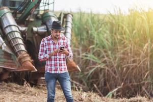 Rural businessman checking work. Sugarcane harvester machine. Farmer. photo