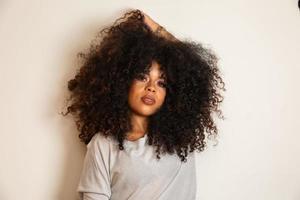 retrato de belleza de mujer afroamericana con peinado afro y maquillaje glamuroso. mujer brasileña. raza mixta. Pelo RIZADO. peinado Fondo blanco. foto