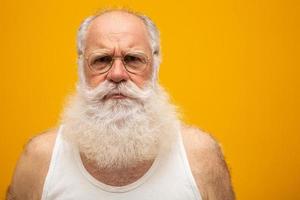 anciano con una barba larga sobre un fondo amarillo. senior con barba blanca completa. anciano con barba larga con tristeza. foto