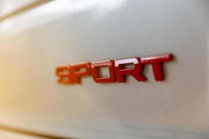 deporte emblema escrito pegado en la parte trasera de un coche deportivo