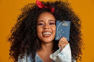 Beautiful curly-haired girl in travel. Next trip. Girl holding brazilian passport. photo