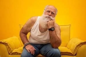 Old man with a long beard on a yellow background. Senior with full white beard. Old man with a long beard with sadness. photo