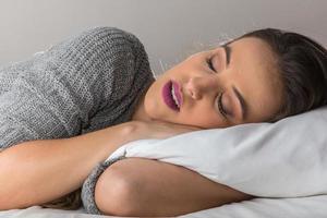 Beautiful woman sleeping on comfortable pillow in bed at home photo