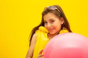 Child wearing life jackets. On yellow background. photo