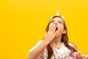 Child in pajamas on yellow background. Concept of sleep, night asleep. photo