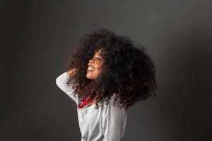 retrato de belleza de mujer afroamericana con peinado afro y maquillaje glamoroso. mujer brasileña. raza mixta. Pelo RIZADO. peinado fondo negro. foto