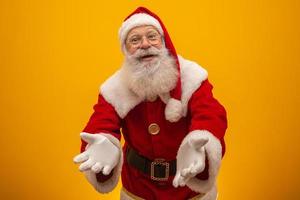 Santa Claus on yellow background with copy space. Presenting. photo