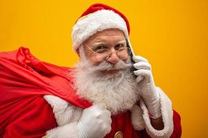 Holly jolly x mas Santa in headwear, costume, black belt, white gloves brings gifts for kids, prepared to celebrate, sale promotion, winter december, chatting on telephone. Santa talking on the phone
