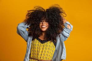 Beauty portrait of african american woman with afro hairstyle and glamour makeup. Brazilian woman. Mixed race. Curly hair. Hair style. Yellow background. photo