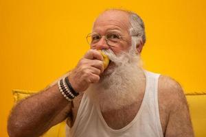 retrato de un hombre barbudo a punto de comer una manzana. senior con una manzana. foto