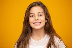 retrato de una niña sonriente feliz de fondo amarillo. foto