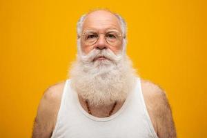 Old man with a long beard on a yellow background. Senior with full white beard. Old man with a long beard with sadness. photo