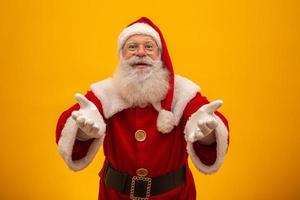 Santa Claus on yellow background with copy space. Presenting. photo