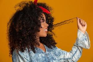 Beauty portrait of african american woman with afro hairstyle and glamour makeup. Brazilian woman. Mixed race. Curly hair. Hair style. Yellow background. photo