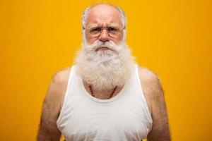 Old man with a long beard on a yellow background. Senior with full white beard. Old man with a long beard with sadness. photo