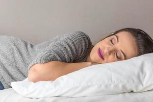 Beautiful woman sleeping on comfortable pillow in bed at home photo