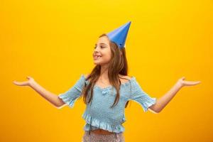 Cute little girl celebrates birthday. Closeup portrait on yellow background. photo