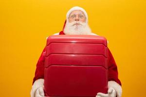 Santa Claus with his suitcase. New Year's travel concept. Santa Claus at the airport. photo