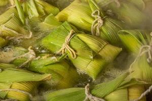 postre de maíz dulce brasileño llamado pamonha. fiesta de fiesta junina. cultura brasileña. cocinando en la sartén. estufa de leña. foto