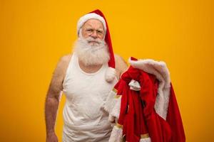 Santa holding his clothes after or before delivering presents. Santa's clothes. Costume. Serious. photo