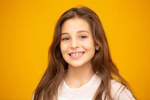 retrato de una niña sonriente feliz de fondo amarillo. foto