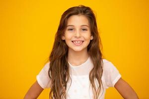 retrato de una niña sonriente feliz de fondo amarillo. foto