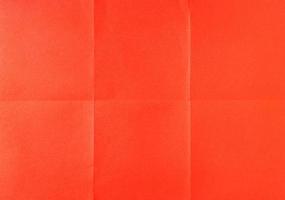 Red crumpled unfolded paper sheet texture background. Paper folded in six. Full frame photo