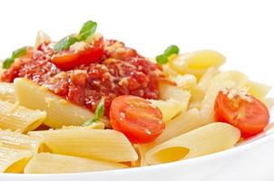 Penne pasta with bolognese sauce, parmesan cheese and basil photo