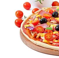 Pizza with vegetables, chicken, ham and olives isolated on white photo