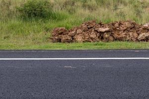 Asphalt road surface with a pile of dirt. photo