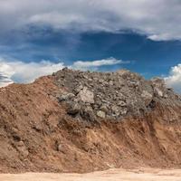 Underneath the ground, dig and pile the rocks with skies. photo