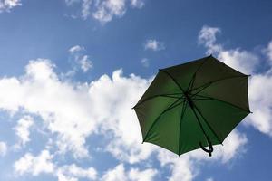 A close-up view from the low, a beautiful green umbrella floating freely. photo