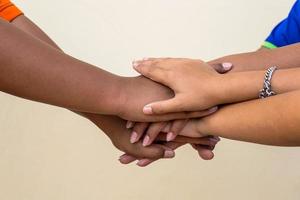 A close-up view of the hands of three Thai children interlacing each other in layers. photo