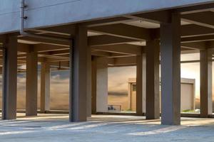 Sunlight shines through the concrete pillars under the building. photo