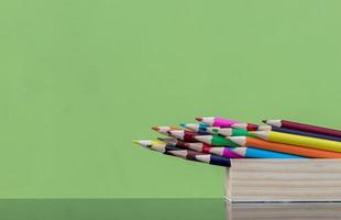 Crayons in a wooden box with green walls. photo