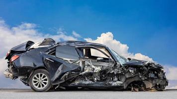 The wreckage of a black sedan smashed into wreckage until it turned into scrap in a fatal collision. photo