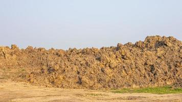 A hillside view of a large pile of soil which is left on the ground. photo