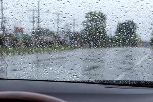 Rain drops on the windshield with the road. photo