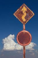 viejo cartel de tráfico curvo con nubes de cielo. foto