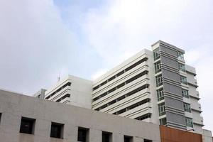A low-down view, a close-up view of the white concrete building of a large old hospital. photo