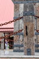 Old wooden pole with rusty chain rust. photo