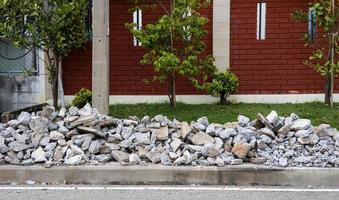 A pile of concrete rubble near a brick wall. photo