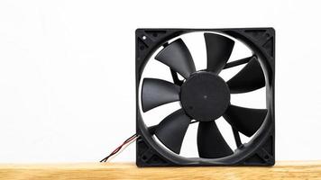 Close-up view of a computer fan isolate is placed on a wooden floor . photo