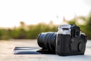 A close-up view of an old black camera and a sheet of film. photo