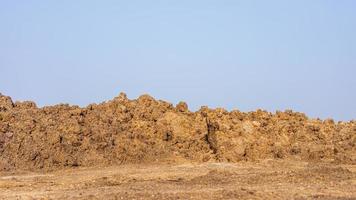 A hillside view of a large pile of soil which is left on the ground. photo