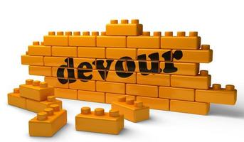 devour word on yellow brick wall photo