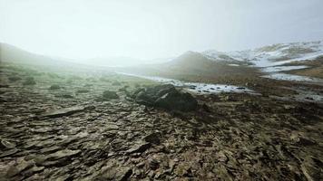 colina rocosa cubierta de nieve en medio del desierto en un día nublado video