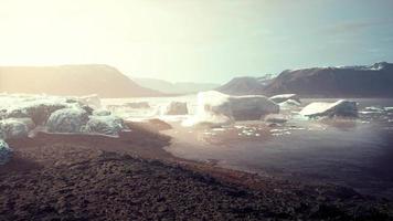 gigantic Ice block structures on the black sand by the sea shore video