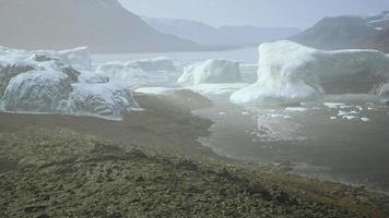 gigantic Ice block structures on the black sand by the sea shore video